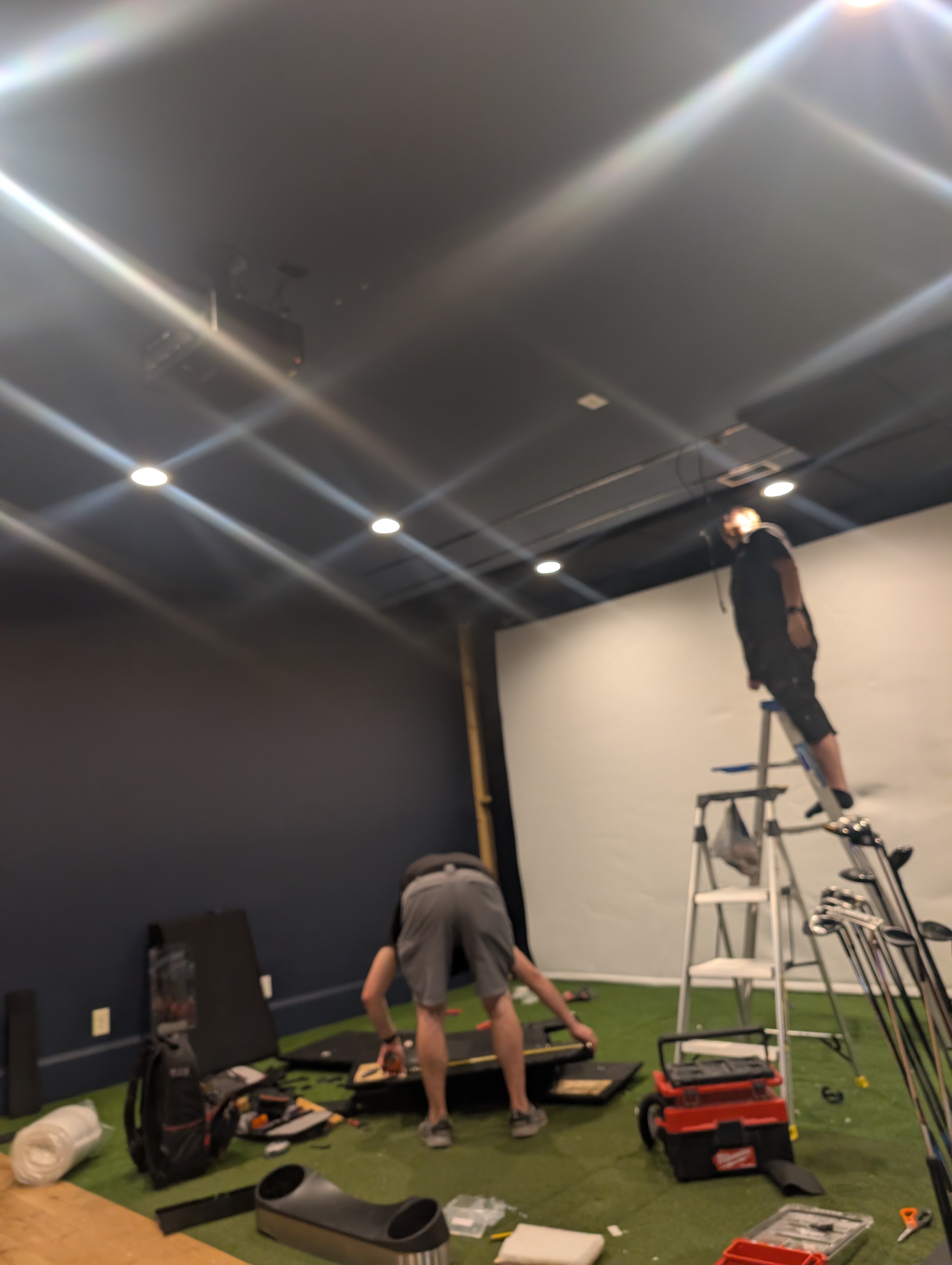 ETI technicians installing protective panels in a custom golf simulator room
